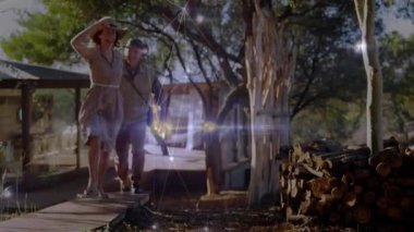 Bir çift köy kulübesinden yürüyüş yoluna çıkıyor, seyahat reklamında el ele tutuşup gülüyorlar. Kırsal, çift, açık hava, uyum, macera, boş zaman, doğa