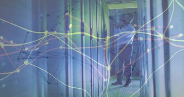 Veri merkezi koridorundaki sunucu bağlantılarını LED ışıkları ve kopyalama alanı ile ayarlayan yönetici denetleniyor. Teknoloji, siber güvenlik, ağ, altyapı, dijital, profesyonel, modern