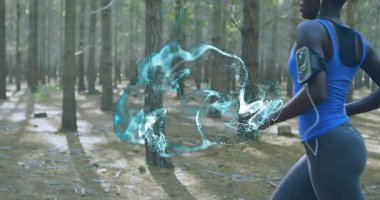 Kadın çam izine doğru koşuyor turkuaz holografik kurdeleyi etkinleştiriyor fitness verisini görselleştiriyor. Doğa, teknoloji, fitness, dijital, açık hava, sağlık, atletizm