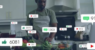 Sebzeleri doğrayan, çiftlerin etrafında dönen ikonlar yakan aşçılık nişanı yükselten bir adam. Mutfak, sosyal medya, etkileşim, modern, yaşam tarzı, canlı, takım çalışması