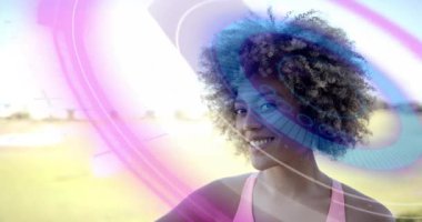 Pembe girdaplar, süpürülen mavi yüzükler, dönen kadın yükselen kollar çapraz yüz, reklamlar için saçlar. Kadın, açık hava, fitness, atletik, arka ışıklandırma, mercek, park