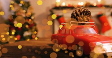 Sürüklenen bokeh, döndürülen kırmızı oyuncak arabaları ortaya çıkarıyor, çam kozalaklarını gösteriyor, tatil sahnelerini gösteriyor. Kutlama, tatil, konforlu, nostaljik, kaprisli, sıcak, kutlama