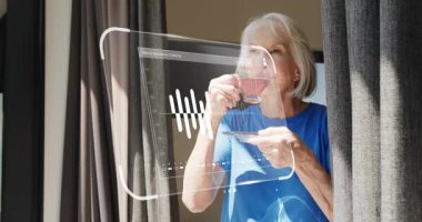 Elinde çay fincanı tutan kadın, 123456CA sayılı finans hesabı için bar tablosunu aktifleştiriyor. Yaşlılık, rahatlama, dijital, ev, tefekkür, konfor, huzur