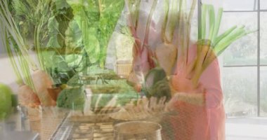 Kadın ve erkek tezgaha sepet koyuyor, sebzeleri duruluyor, sağlıklı yemek için doğruyor ve soteleniyor. Bahçıvanlık, beslenme, sağlık, ev tarzı, sürdürülebilirlik, bol, sağlıklı