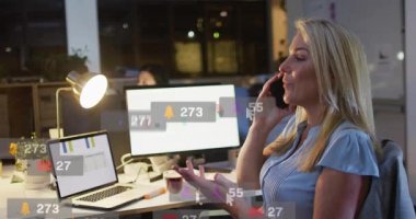 Ofis müdürü telefonda konuşuyor. Dosyaları izlerken sosyal medya kartlarının büyümesine neden olan bir arama. Çalışma alanı, çoklu görev, işbirliği, verimlilik, akşam, çift izleme, masaüstü