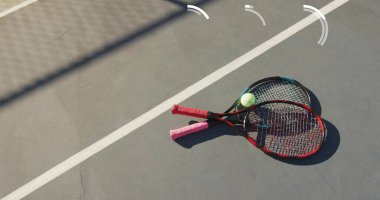 Çapraz tenis raketlerini tenis topuyla, fotokopi alanıyla dışarıda sergiliyor. Spor ekipmanları, atletizm, oyun, eğlence, açık hava, rekabetçi, aktif
