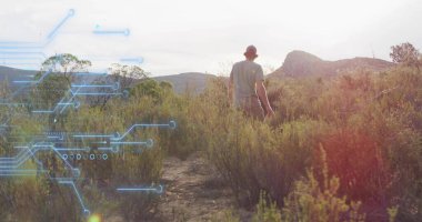 Dar toprak pistte güneşli, yuvarlanan tepelere bakan yalnız ve yetişkin bir erkek yürüyüşçü. Macera, keşif, vahşi doğa, doğa, açık hava, engebeli, panoramik
