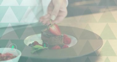 Şef nane şekeriyle pasta süslüyor, geri çekiliyor, enerji maliyetini gösteren deniz mavisi simgelerini başlatıyor. Gurme, sunum, zarafet, zanaat, yenilik, aşçılık, sofistike