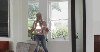 Son sınıf öğrencisi bir kadın hediye kutusuyla içeri giriyor. Yetişkin bir kadının elini tutuyor. Yetişkin bir erkeğin elini tutuyor. Aile, kutlama, bağ, sıcaklık, ev, birliktelik, neşe