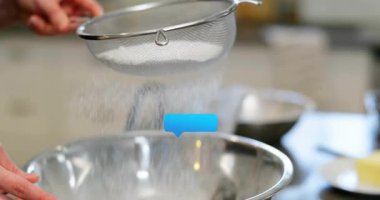 Yemek klipsi, adamın ellerinin kase içine un elleyerek yüzen sohbet baloncukları gibi süzdüğünü gösteriyor. Mutfak, pişirme, yemek hazırlama, mutfak, teknik, süreç, modern