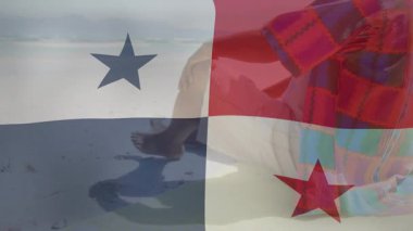 Kamera çalışıyor, kıdemli adam sahilde oturuyor, Panama bayrağını geziyor harmanlıyor, ufka bakıyor. Yaşlı, beyefendi, kıyı şeridi, deniz, ekose, desenli, yalın ayak