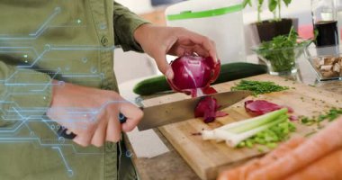 Tezgahta soğan dilimleyen ev aşçısı mavi devre havada süzülürken katmanları soyuyor. Mutfak, yemek hazırlama, aşçı, mutfak gereçleri, taze ürün, sağlıklı beslenme, işçilik.