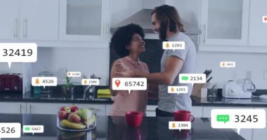 Mutfak barında el ele tutuşan çift, sosyal medya simgeleriyle bağlantı kurarak dans ediyor. Romantizm, kutlama, yakınlık, samimiyet, sıcak, neşeli, canlı