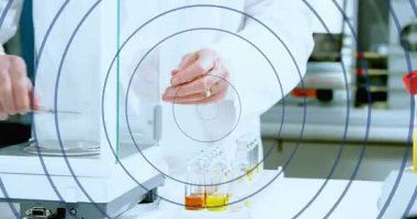 Kıdemli bilim adamı kalkanı açıyor, şişeleri hareket ettiriyor, test için matarayı emniyete alıyor, çerçeveleri örtüyor. Laboratuvar, bank, analitik, denge, cam, beher, numune