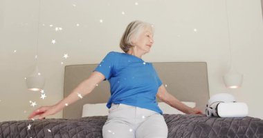 Kıdemli kadın gövdesini oynatıyor, beyaz VR kulaklık takıyor, sanal ortama daldırıyor. Yaşlılar, rahatlama, yenilik, eğlence, teknoloji, refah, rahatlık.