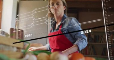 Zaman çizelgesine bakan yiyecek verilerini takip eden bir kadın güncelleme yapıyor ve güvertede yeşil soğan dilimliyor. Beslenme, sağlık, aşçılık, yaşam tarzı, sağlıklı beslenme, mutfak, modern.