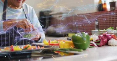 Kıdemli bir kadın biber üzerine biber serpiştiren otları eğiyor, soğanları da baharatlandıran teknolojiyle kaplıyor. Yemek pişirme, mutfak, mutfak eşyaları, yemek hazırlama, modern tasarım, sağlıklı beslenme, yaşam tarzı