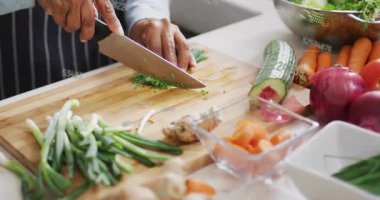 Ev aşçısı kesim tahtasına otları yerleştiriyor ve yemek hazırlamak için canlı etiketlerle otları doğruyor. Aşçılık, aşçılık, taze malzemeler, yemek hazırlama, mutfak, yaşam tarzı, geleneksel