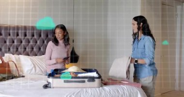 Arkadaşlar seyahat için bavullarını toplarken tablet üzerinde doğrulama yapıyor ve yeşil bulut simgesini etkinleştiriyorlar. Seyahat, toplanma, arkadaşlık, günlük, yaşam tarzı, planlama, hazırlık