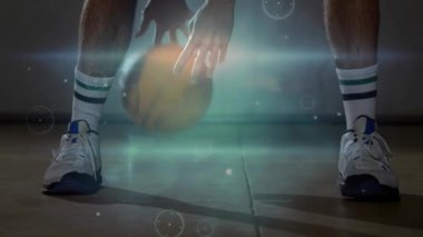 Basketbolcu top düşüşü, kamera yükselişi, oyuncunun üzerinden geçen top sürme pratiği yapıyor. Mahkeme, atlet, forma, şort, çorap, spor ayakkabısı, konsantrasyon