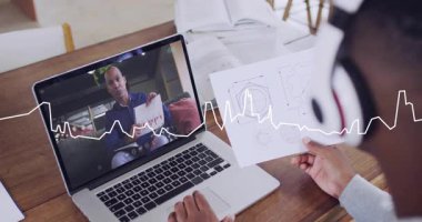 Özel öğretmen, öğrencinin dizüstü bilgisayarındaki çizimleri incelemek için eşleştirirken dalga biçimine neden oluyor. Uzak, öğrenim, ev, masa, işbirliği, odaklanma, konsantrasyon