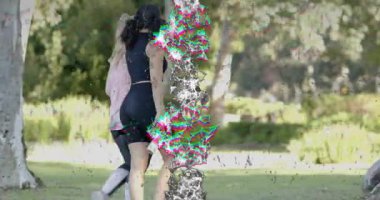 İki kadın parkta yürüyen spor salonu istatistikleri, ağaçların yanında dinleniyor gökyüzünü işaret eden suyu yudumluyorlar. Açık hava, dostluk, sağlık, rahatlık, doğa, su, egzersiz.