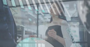 İş toplantısında el kol hareketi yapan ve açıklama yapan bir kadın, deniz mavisi çizelgelerinin değişmesi, aylık verilerin açığa çıkması. Bilgi grafikleri, işbirliği, şirket, cam, disk bölümü, modern, ofis