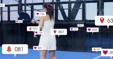 Padel kortunda sallanan bayan sporcu topa vuruyor ve ortak olarak kalpleri atıyor. Spor, fitness, digital, modern, takım çalışması, aktif, canlı