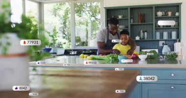 Doğrama başladığında, baba rehberliği oğlu yemek pişirirken, rozetler tezgahın üzerinde yükselirken nişanı gösteriyor. Aile, akıl hocalığı, aşçılık, dijital, teknoloji, ev, canlı