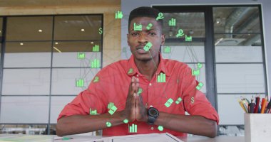 Kırmızı tişörtlü bir adamın elinde yüzen veri simgeleriyle bürodaki kağıtları incelemesi. Profesyonel, dijital, minimalist, iş, işbirliği, modern, analitik