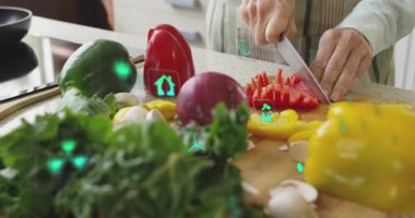 Holografik ikonlar her kesilen yemeğe tepki verirken biber dilimleyen bir kadın. Aşçılık, aşçılık, teknoloji, yenilik, sağlık, organik, mutfak donanımı