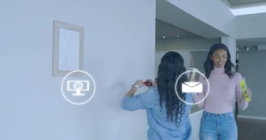 Kadınlar mezura uzatıyor, yüzen simgeleri aktifleştiriyor, ev dekorasyonu için duvarı işaretliyor ve çekiçliyor. İşbirliği, iç mekan, modern teknoloji, yaratıcılık, arkadaşlık, diy