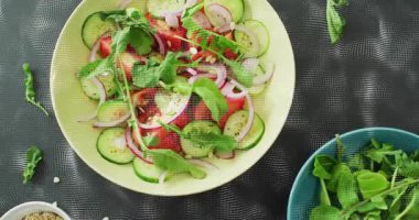 Yavaşça yukarı doğru çekilen kamera, soluk sarı kaseyi yukarı kaldırıyor ve siyah hasırda tohum kabını ortaya çıkarıyor. Tazelik, sağlık, malzemeler, aşçılık, hazırlık, minimalizm, doğal