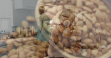 Kahve tomarlı telefonu yudumlayan bir kadın yemek için badem kaplamasına neden olurken, erkek fasulye öğütüyor. Selamlama, rahatlama, samimiyet, konforlu, modern, yeni yaşam tarzı, birliktelik