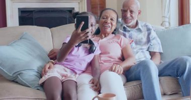 Torunu büyükannesinden akıllı telefonu kapıyor ve kutlama teknolojisini konfetiye çeviriyor. Aile, jenerasyonel, bağlantı, sıcaklık, mutluluk, teknoloji, rahatlık