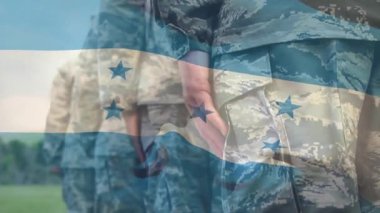 Askeri tatbikatta el ele tutuşan askerleri odaklayan kamera, üniformayla harmanlanan bayrak. Kamuflaj, düzen, geçit töreni, renkler, bayrak, alan, birlik