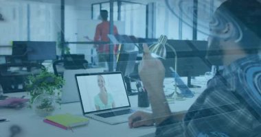 Adam ofis masasında oturmuş uzaktan iş arkadaşı el salladıktan sonra dizüstü bilgisayara el sallıyor. İşbirliği, takım çalışması, tele-varlık, diyalog, odaklanma, gün ışığı, modern
