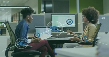 Sol kadın dizüstü bilgisayara bakıyor, sağ kadın el kol hareketi yapıyor, iş için ağ bağlantıları kuruyor. İşbirliği, meslektaşlar, takım çalışması, tartışma, açılış planı, ofis, masa