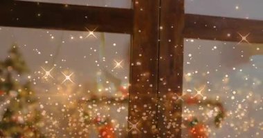 Kamera aşağı doğru kayıyor. Konileri, kablo yıldızını, karı ortaya çıkarıyor. Altın parıltısı sürükleniyor. Rahat, tatil, pencere, şömine rafı, süs, çelenk, çorap