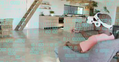 Beyaz VR kulaklık takan adam, teknoloji demosunda turkuaz ikili kaplama kullanarak eşyaları seçiyor. Sanal, etkileşim, jest, sürükleyici, teknoloji, ev, dinlenme odası