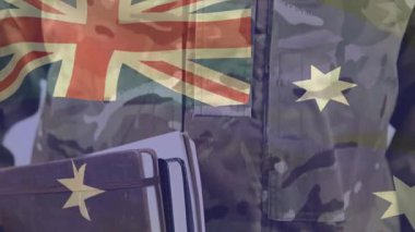 Kamera yükselirken elinde kitap tutan erkek asker portre için Amerikan bayrağıyla yüzünü gösteriyor. Askeri, kamuflaj, üniforma, defterler, vesikalık fotoğraf, Avustralya, stüdyo