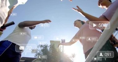 Dört tenisçi net sallamada selamlaşırken raketçi yüzen sosyal simgeleri dinliyor. Yoldaşlık, mahkeme, bariyer, borç, güneş ışığı, açık hava, canlı