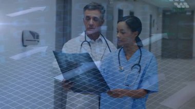 Dr. ve hemşire hastanede duruyor, tedavi için çizelgeyi gözden geçiriyorlar, işaret ediyorlar, olay yerinde ortaya çıkıyorlar. Klinisyenler, klasör, steteskop, koridor, tıbbi, tesis, üst üste