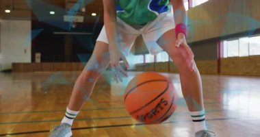 Bayan basketbolcu antrenman için duruş değiştirirken bacaklarının arasından salya akıtarak antrenmana başlıyor. Mahkeme, ahşap, spor salonu, yansımalar, pencereler, kesişim, denge