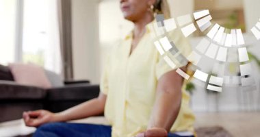 Mudra 'da oturan son sınıf öğrencisi kadın, kamera geri çekiliyor ve mozaik yüzünde iyileşme için dönüşe neden oluyor. Meditasyon, sakinlik, dinginlik, farkındalık, olgunluk, ev, bitkiler