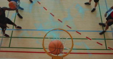 Sol oyuncu basketbolun üst kamerasını bırakıyor. Rant 'in potaya vurup düşürmesini kaydediyor. Üst, çember, saha, spor salonu, top, hareket, ribaund