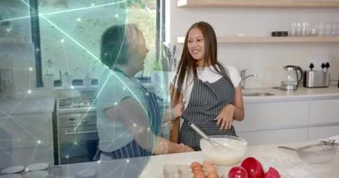 Yemek pişirme ikilisi, karıştırıcı vurucu, kahkahalar sol tarafta dijital küreyi birbirine bağlayan bir beşlik çakmaya yol açıyor. Anne, kız, pişirme, mutfak, yaşam tarzı, aile, akıl hocalığı