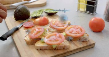 Erkek el avokadoyu hizalıyor, domates dilimlerini güverteye yerleştiriyor, HUD görünüp yiyecek düzenini analiz ediyor. Mutfak, kesme tahtası, tost, yaşam yağı, yakın plan, taze, sağlıklı.