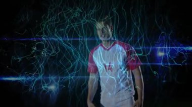 Atletizm sporcusu, gelen futbol topunu koyu sette, deniz mavisi ışık yolları spor yeteneklerini gösteriyor. Oyuncu, neon, stüdyo, hareket, dinamik, çeviklik, odaklanma