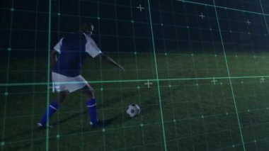 Oyuncu bir adım atıp topa vuruyor ve yeşil şebeke takibi için ileri itiyor. Sporcu, açık hava, gece, futbol, çim, aydınlatma, üst üste bindirme